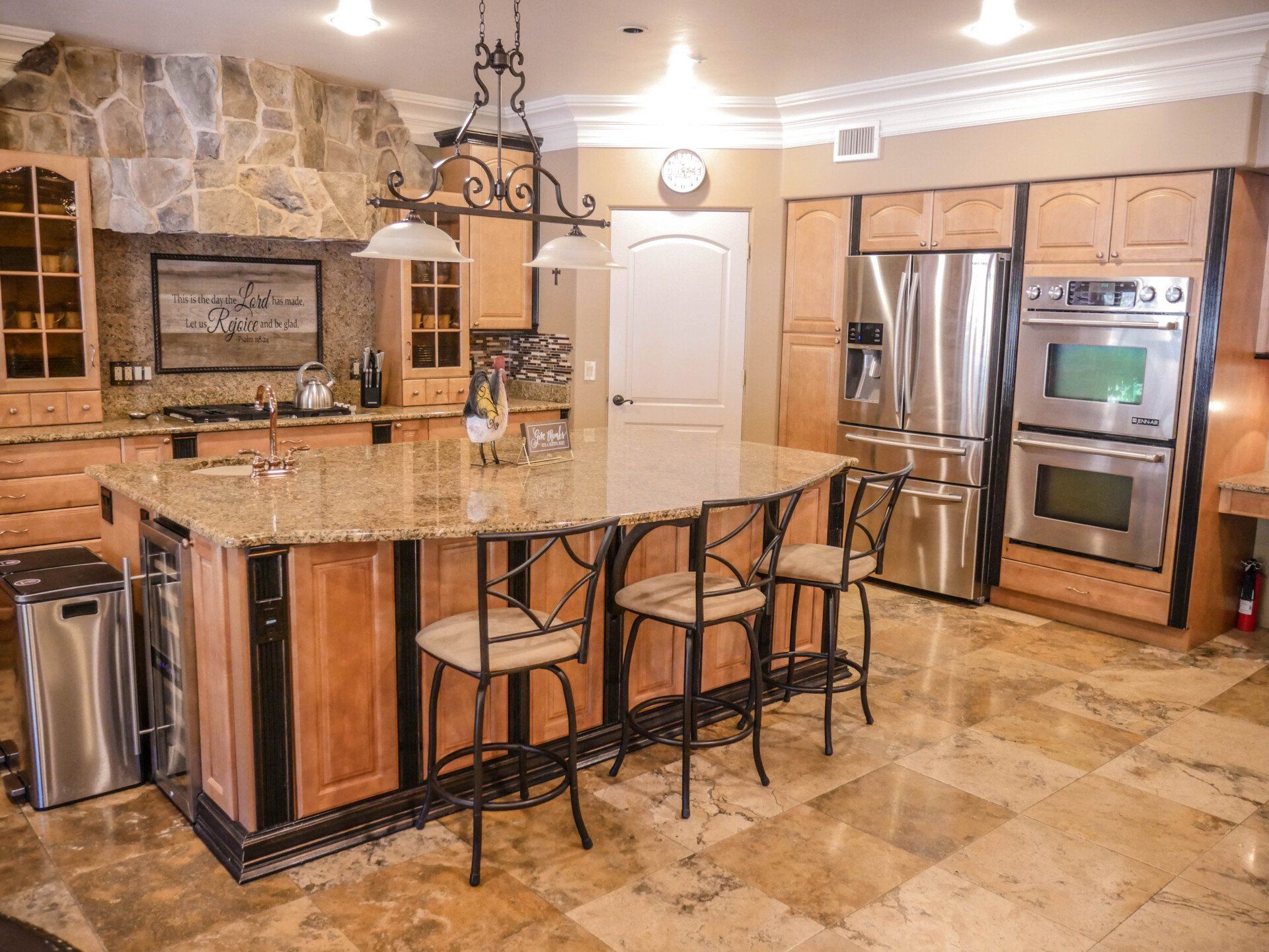 A kitchen with stainless steel appliances , granite counter tops , and wooden cabinets.