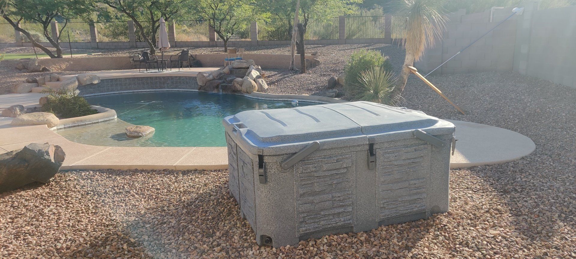 A hot tub is sitting in front of a swimming pool.