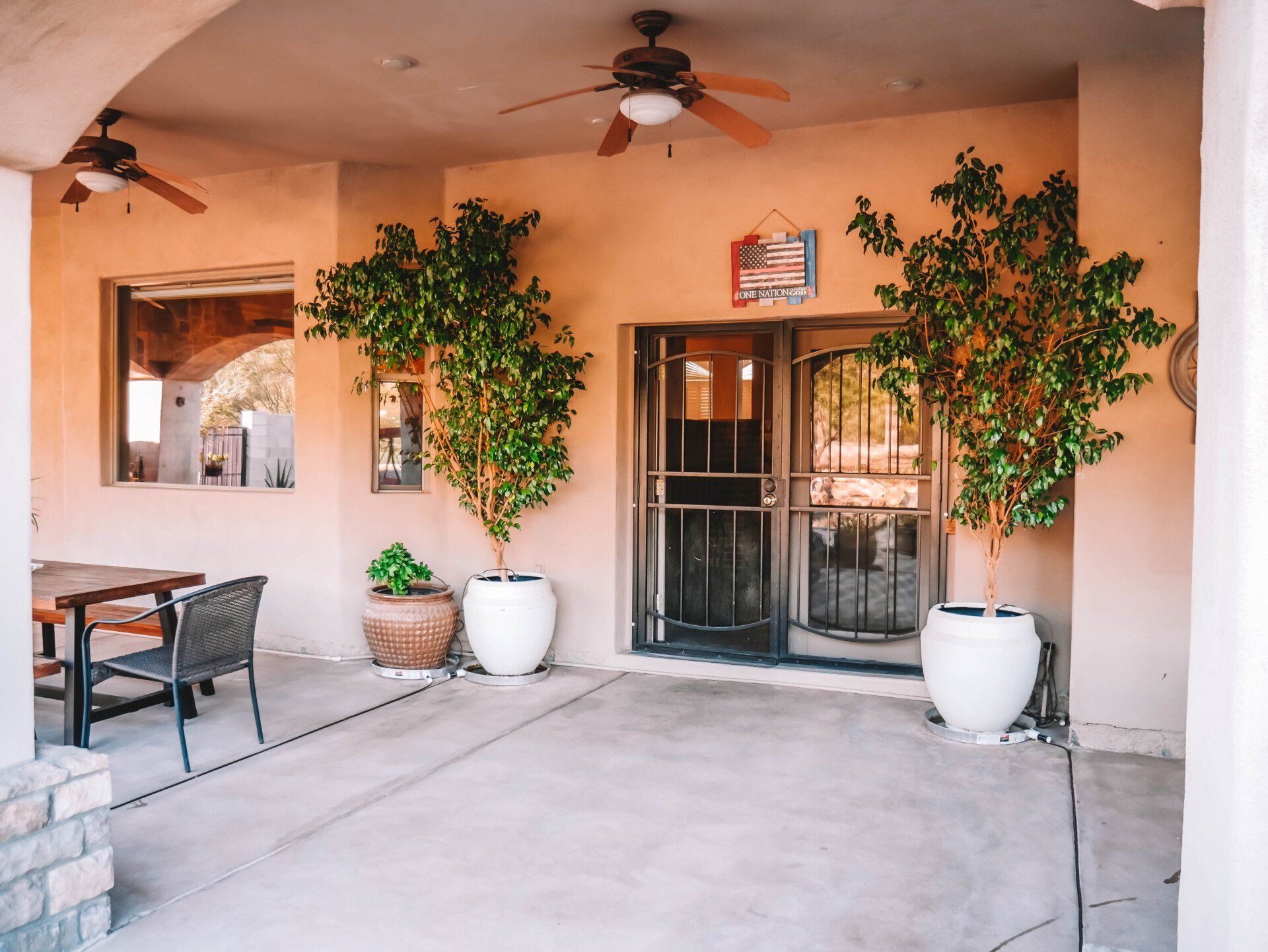 A patio with potted plants and a ceiling fan