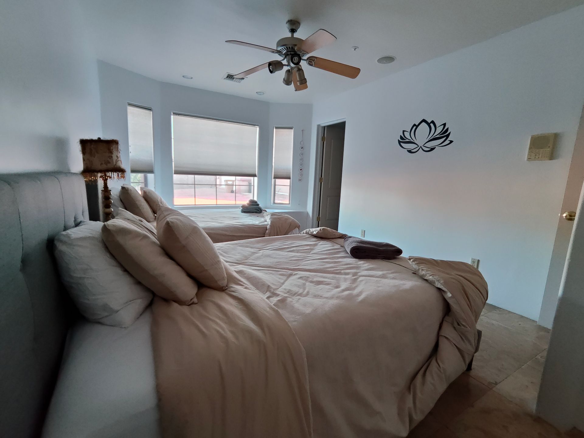 A bedroom with two beds and a ceiling fan.