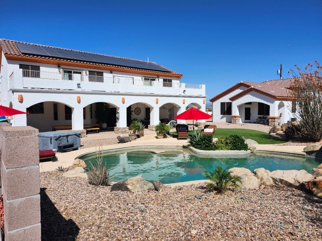 A patio with a lot of furniture and a ceiling fan