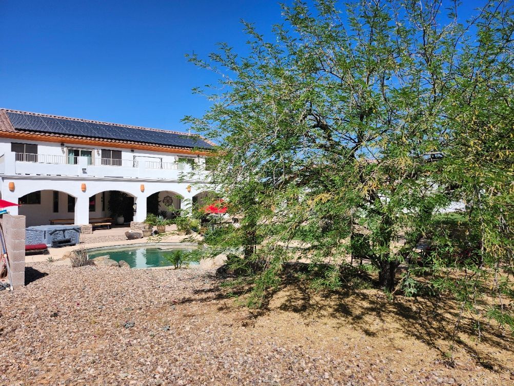 There is a large swimming pool in the backyard of a house.