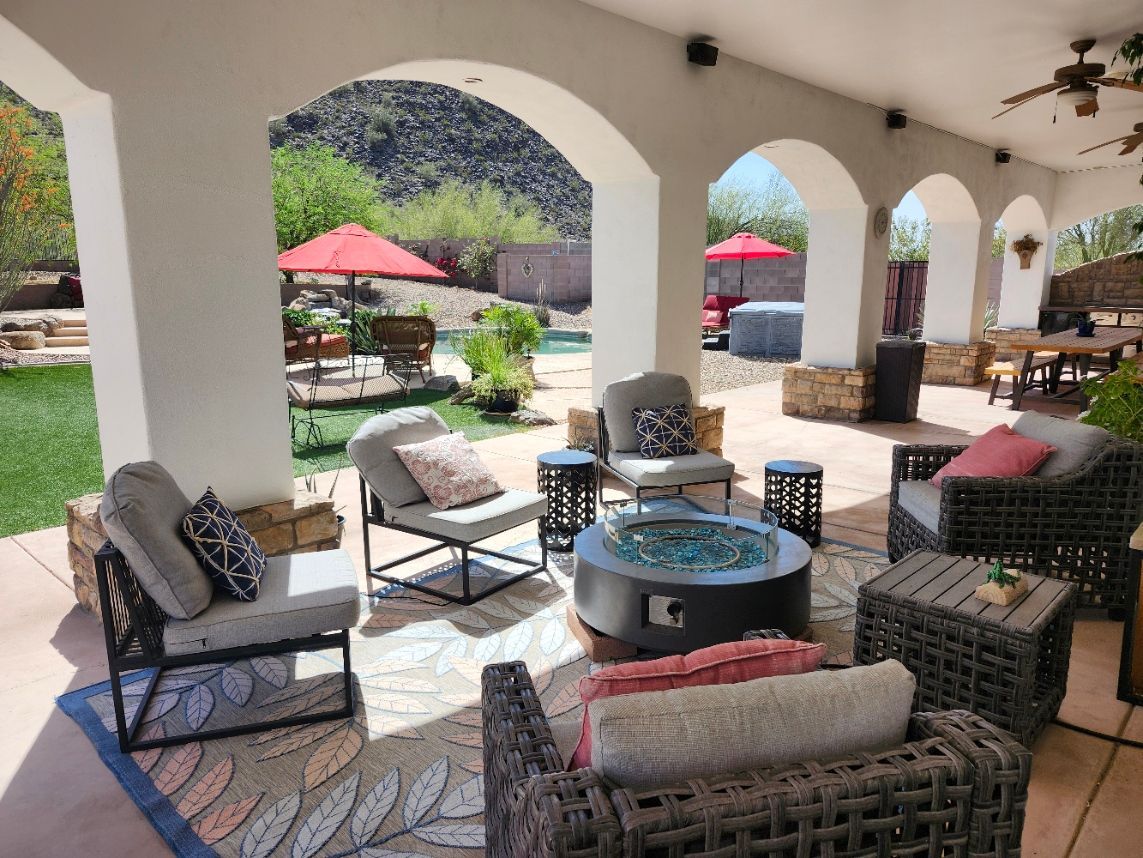 A patio with arches and a lawn in front of it