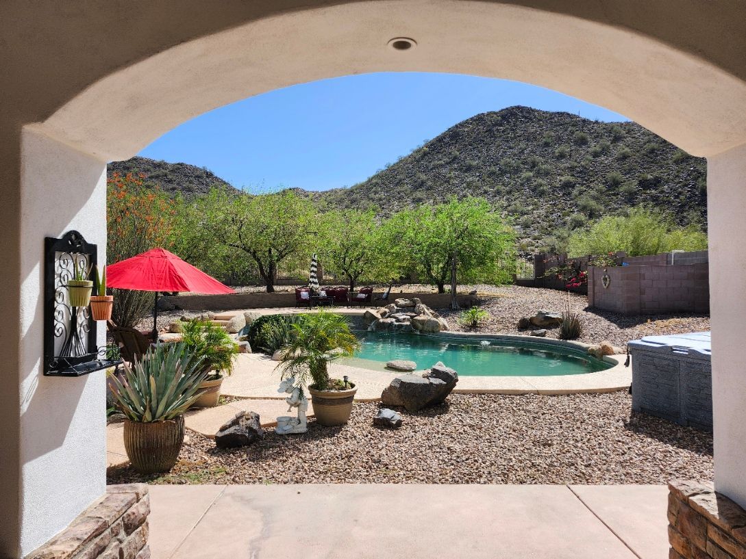 A patio with a fire pit and a ceiling fan