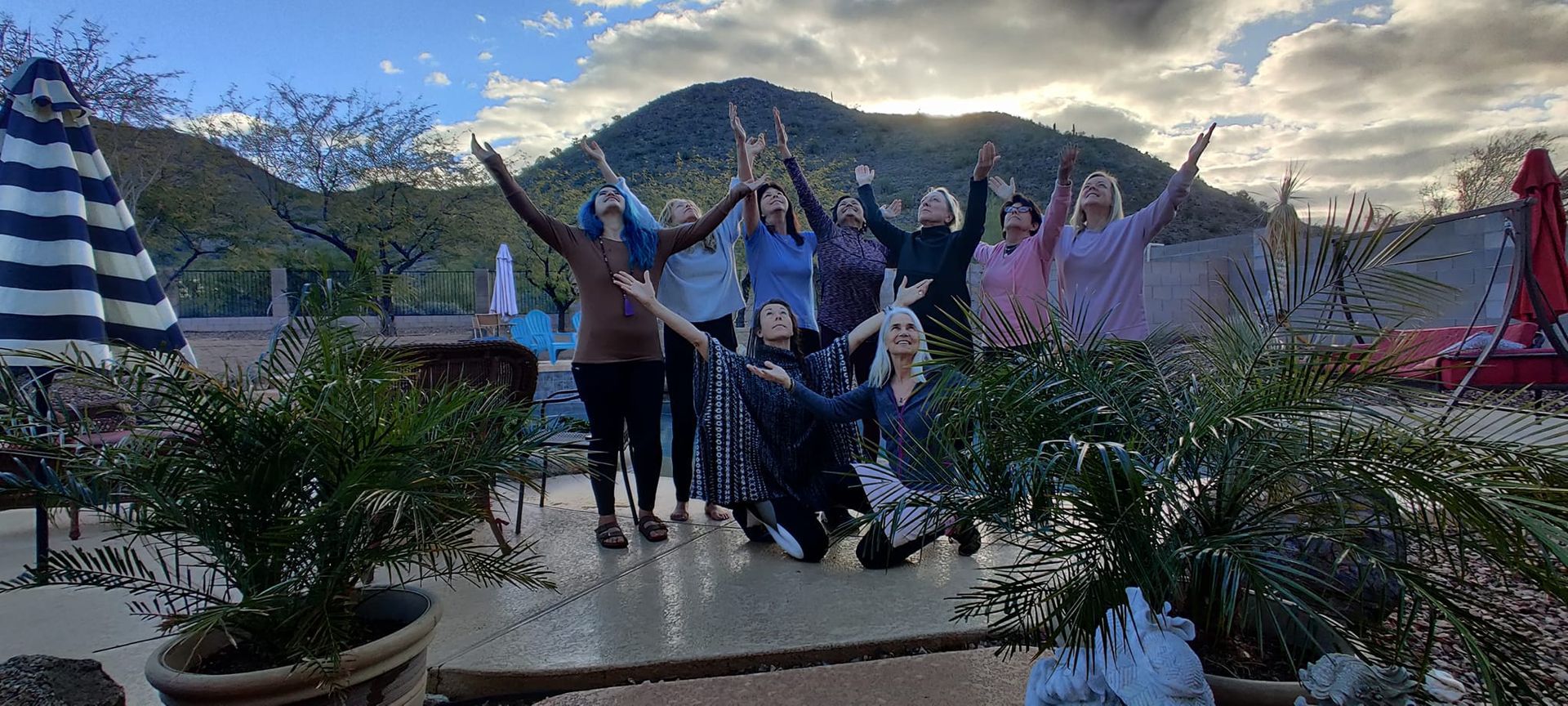 A group of people are posing for a picture with their arms in the air.