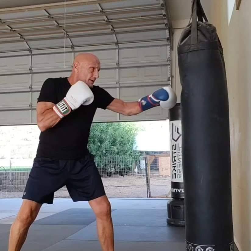 A woman is sitting on a yoga mat next to a dog.