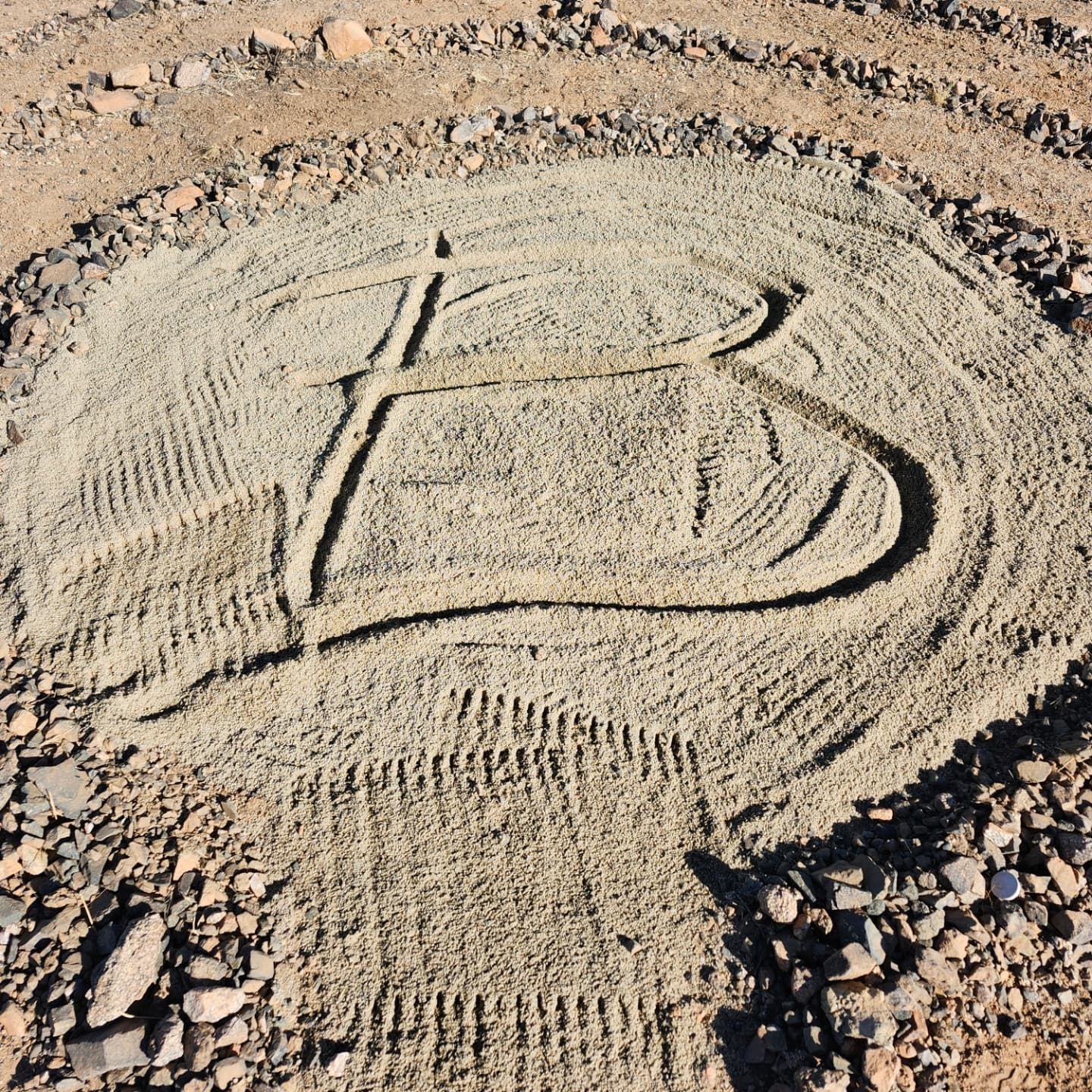 The letter b is written in the sand in a circle.
