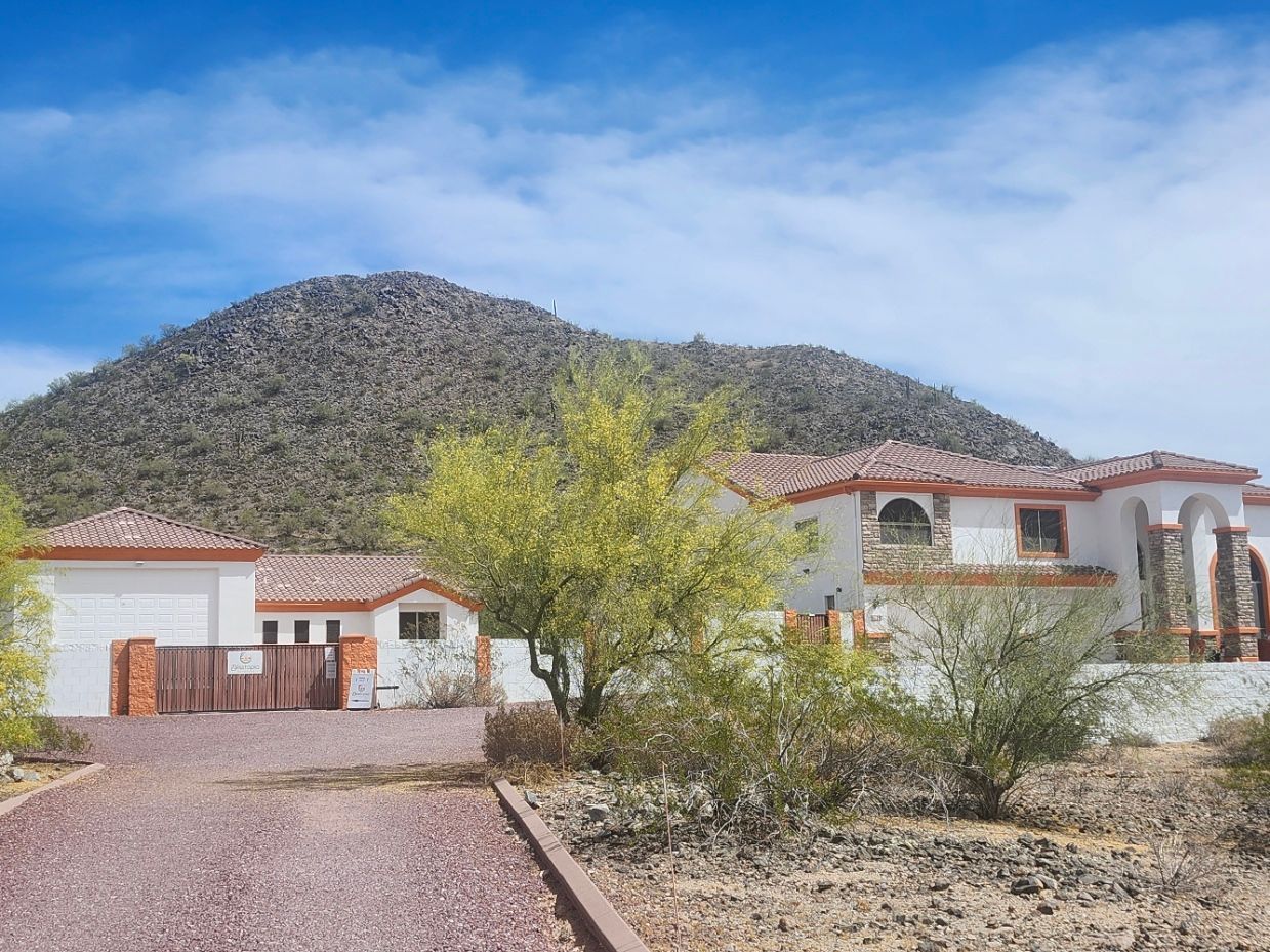 A group of people are standing around a labyrinth made of rocks in the desert.