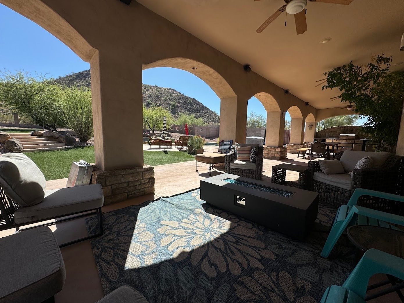 A patio with a fire pit and a ceiling fan