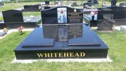 Black granite Whitehead tombstone in a cemetery with a portrait and inscription — Mackay Monumental Masons In Glenella, QLD
