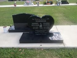 Black granite headstone with heart and rectangle shapes. Inscription with names and dates, on green grass — Mackay Monumental Masons In Glenella, QLD
