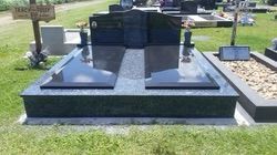 Grave site with black granite headstone and two flat markers. Set in a grassy cemetery — Mackay Monumental Masons In Glenella, QLD