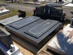 Dark granite double tombstone with cross and names in a cemetery — Mackay Monumental Masons In Glenella, QLD