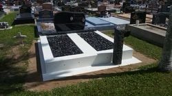 Headstone in a cemetery; white concrete with black gravel sections; black granite monument; sunny day — Mackay Monumental Masons In Glenella, QLD