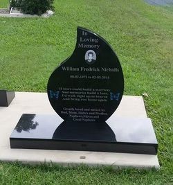 Black granite headstone, teardrop-shaped top, rectangular base. Inscription: