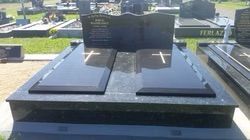 Black granite double tombstone with cross carvings and central inscription panel in a grassy cemetery — Mackay Monumental Masons In Glenella, QLD