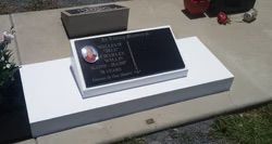 Black granite headstone with photo on a white rectangular base in a cemetery — Mackay Monumental Masons In Glenella, QLD