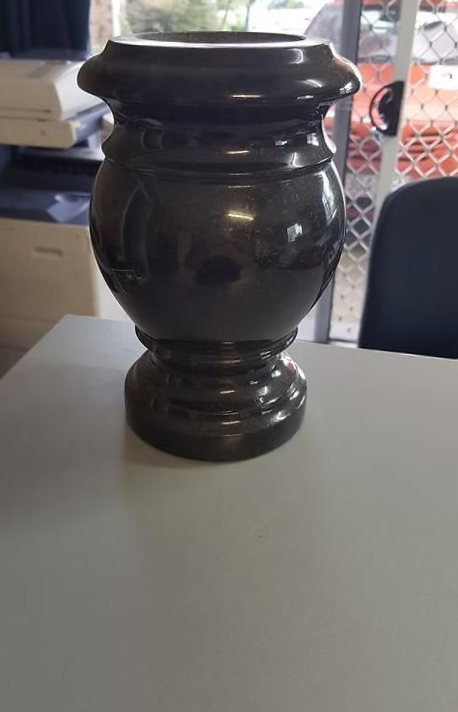 A Black Vase is Sitting on Top of a White Table — Mackay Monumental Masons In Glenella, QLD