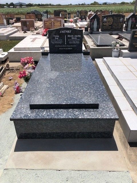 Grave site with a dark granite tombstone, name 