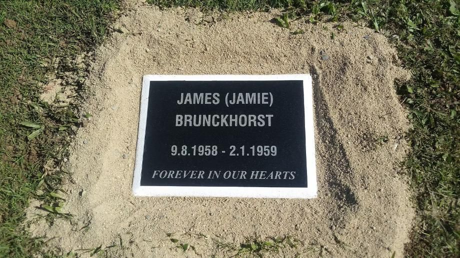 A Black and White Gravestone with Sand on the Side — Mackay Monumental Masons In Glenella, QLD