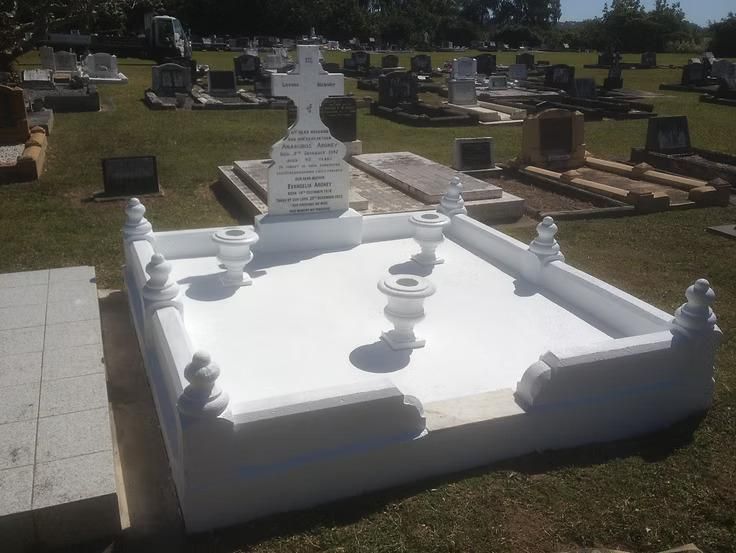 A White Grave With a Cross on Top of It in a Cemetery — Mackay Monumental Masons In Glenella, QLD