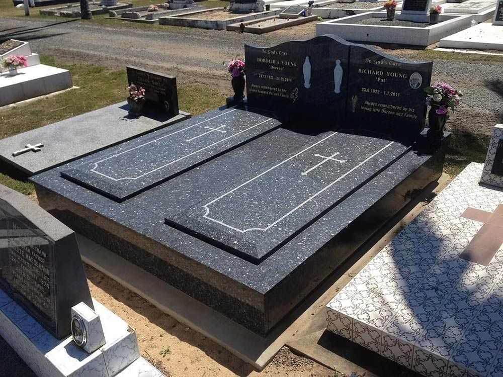 A Black Grave With a Gold Cross on It — Mackay Monumental Masons In Glenella, QLD