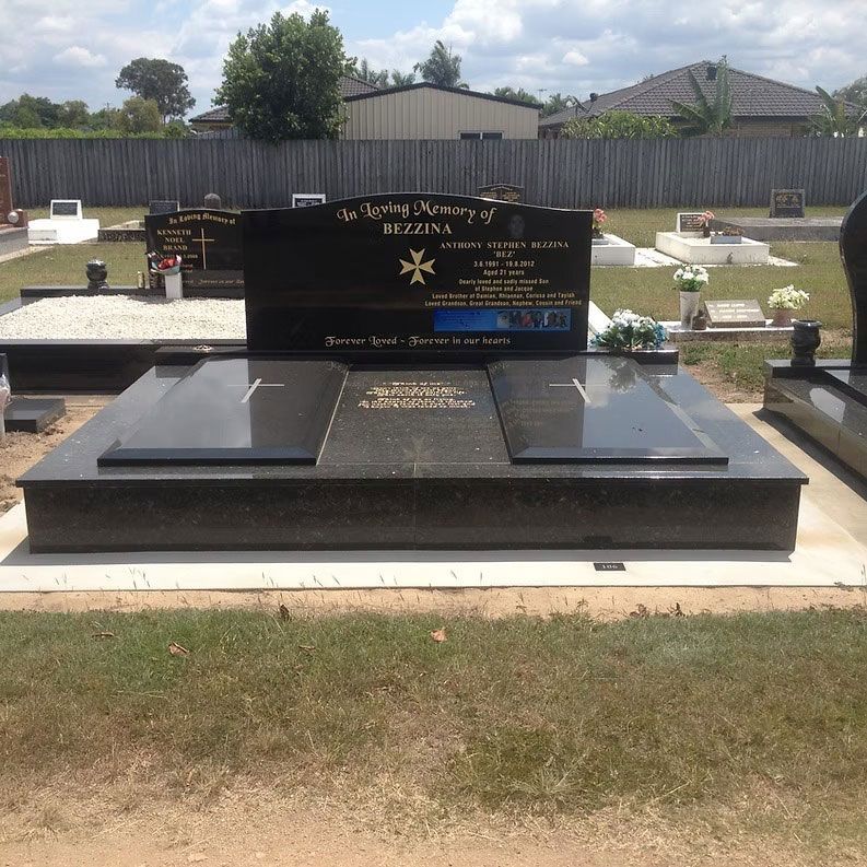 Black Granite Tombstone With Cross, Set in a Grassy Cemetery — Mackay Monumental Masons In Glenella, QLD