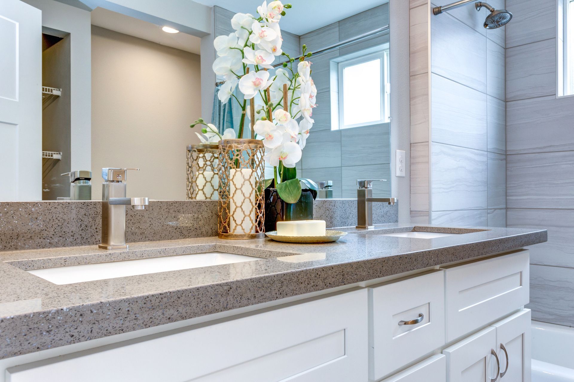 Modern double sink bathroom vanity with quartz countertop white cabinets, orchids and walk-in shower.