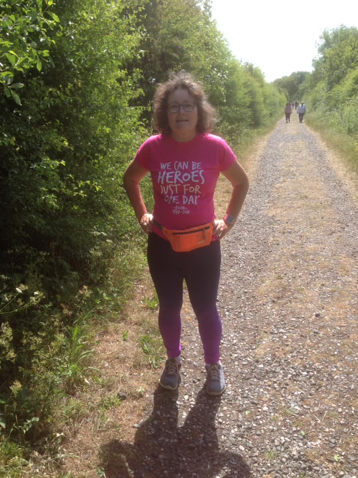 A woman in gym wear posing for the camera as she is walking