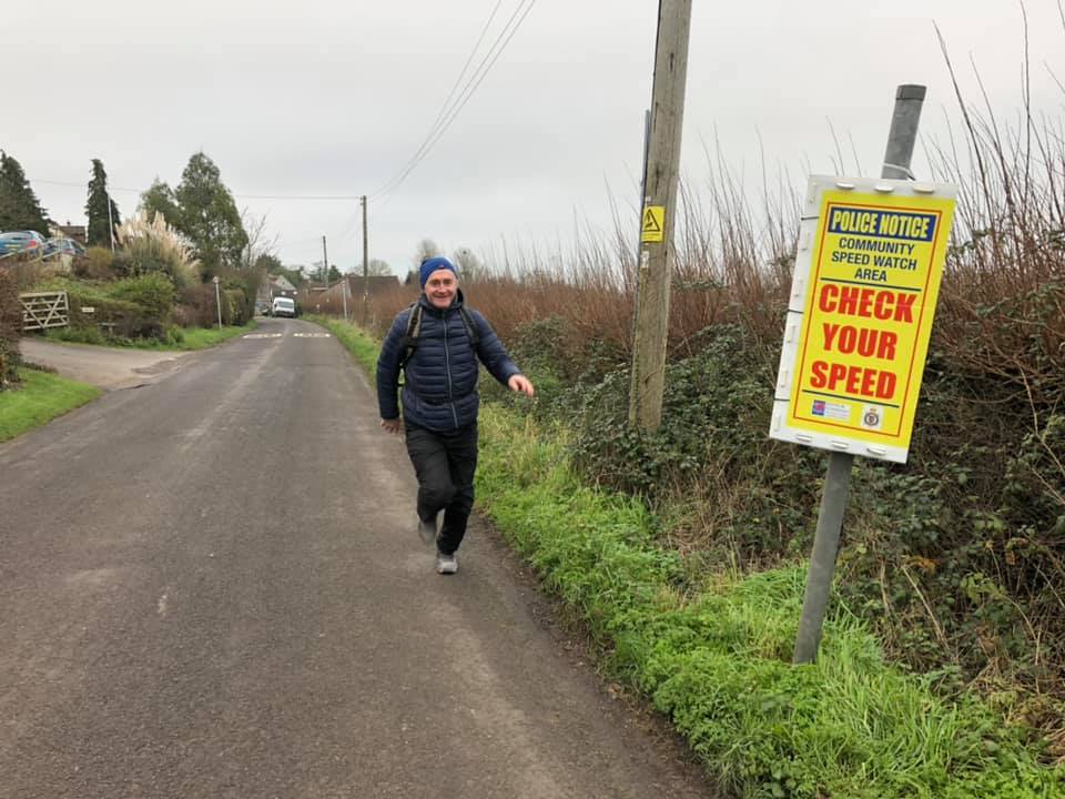 Picture of man walking on a quiet road.