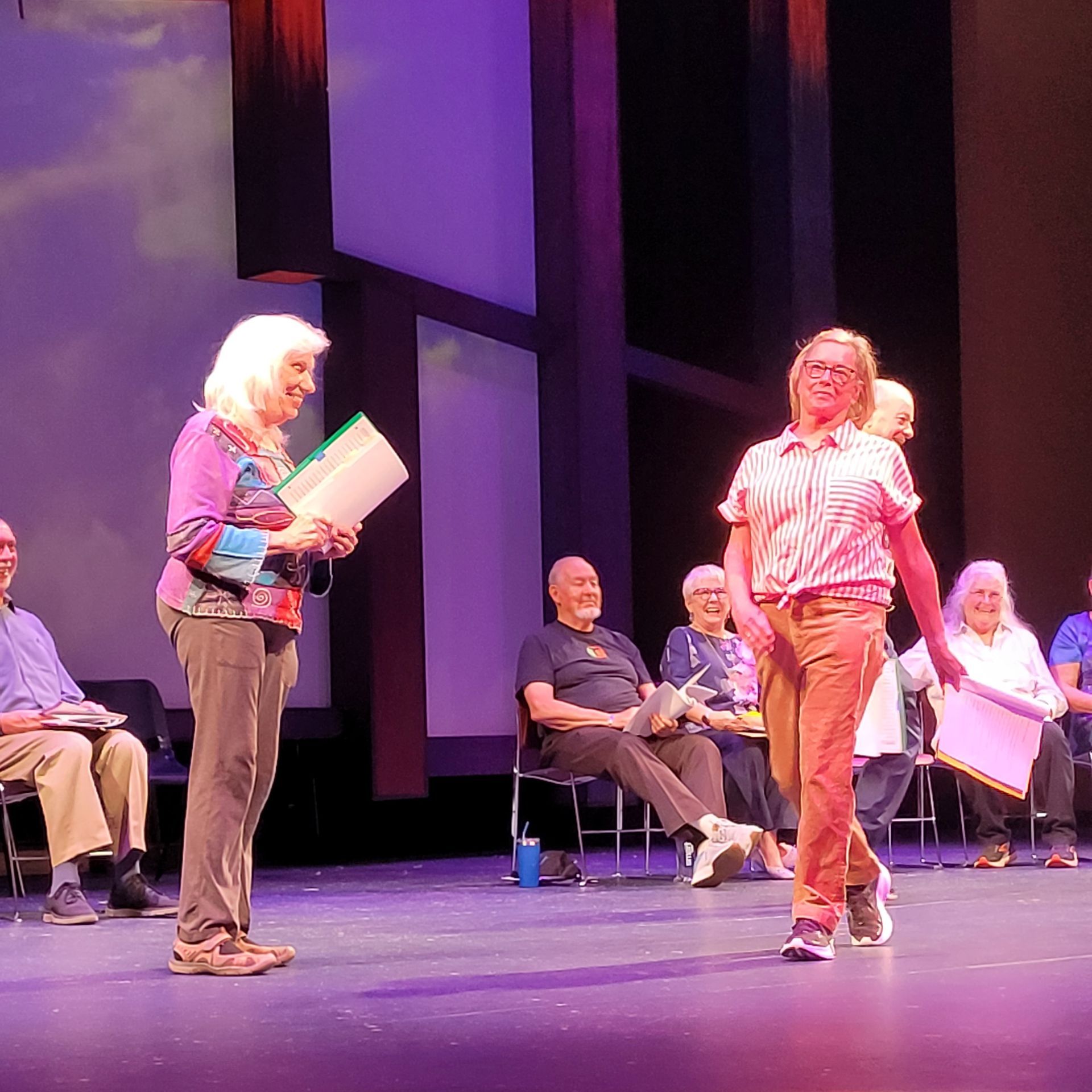 A group of people sitting in chairs and standing on a stage