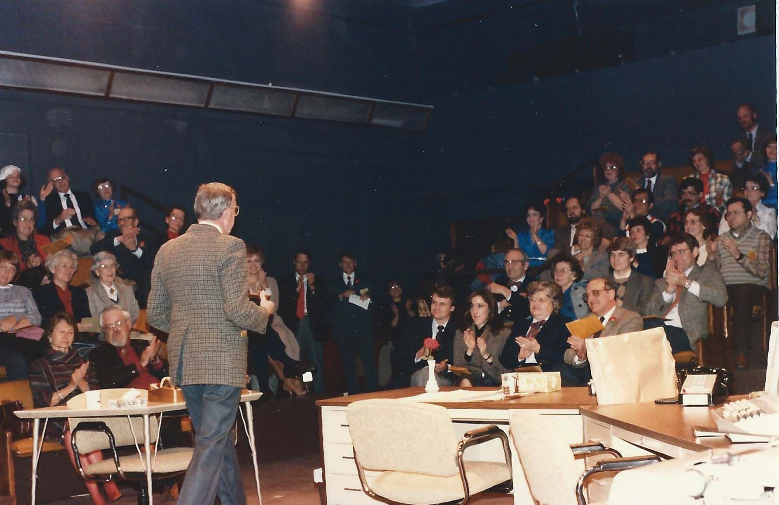 A man is giving a presentation in front of a crowd