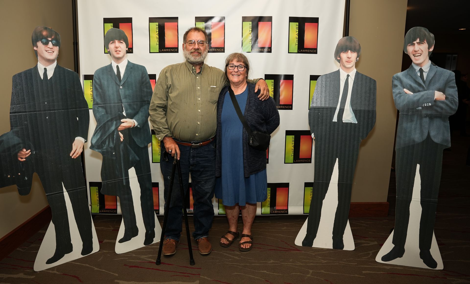 Couple posing with Beatles cardboard cutouts at a promotional event.