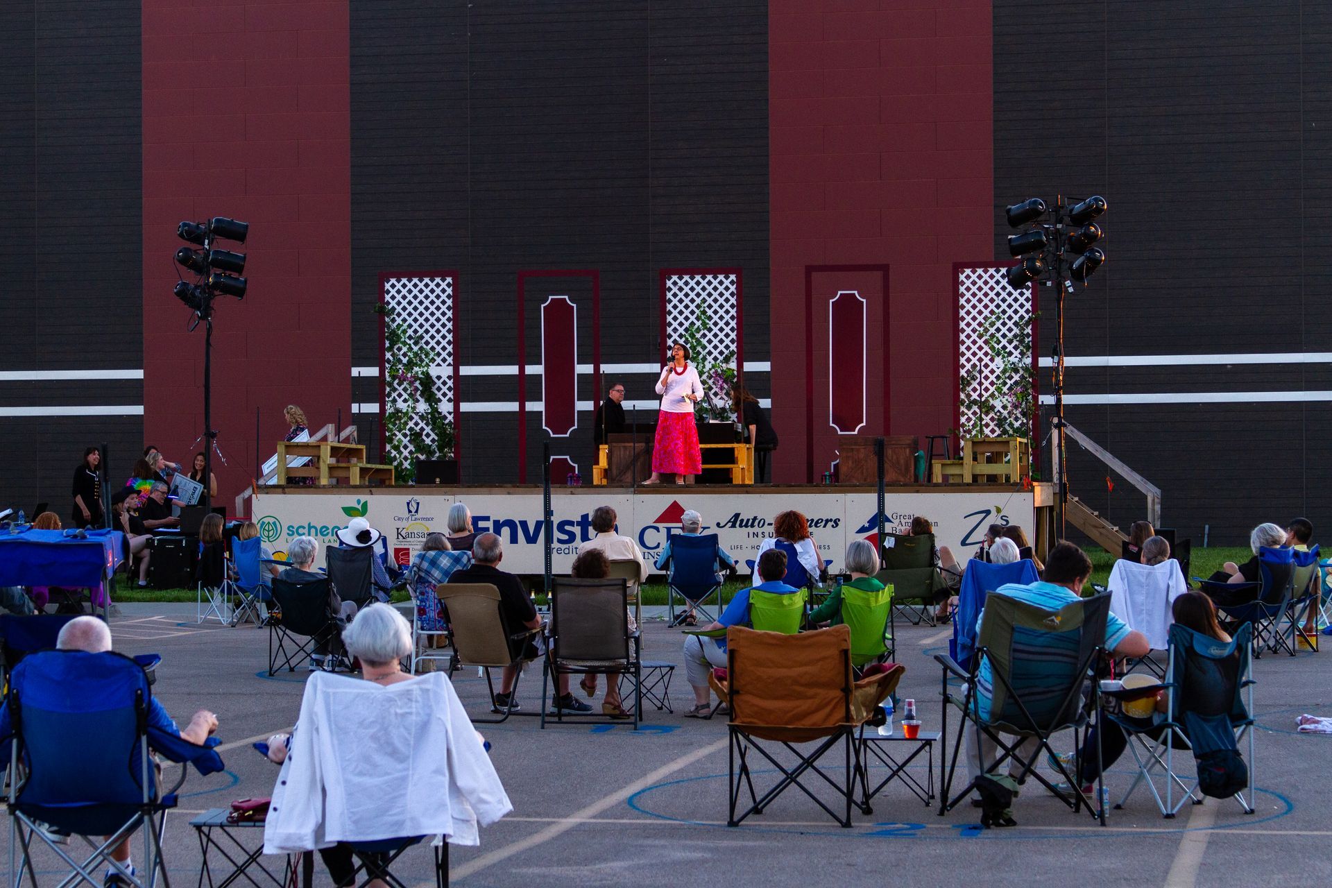 A group of people are sitting in chairs in front of a stage.