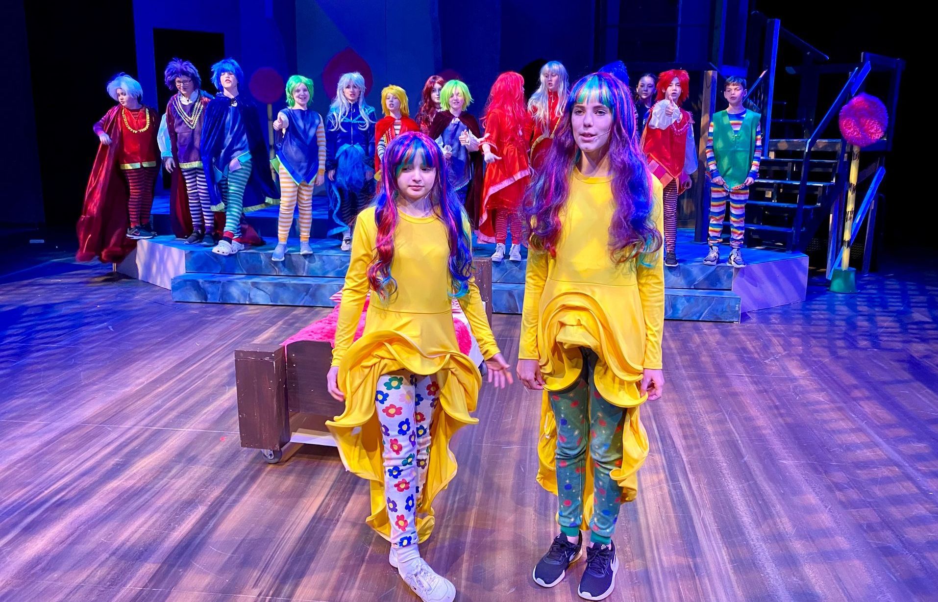 A group of children are standing on a stage in costume.