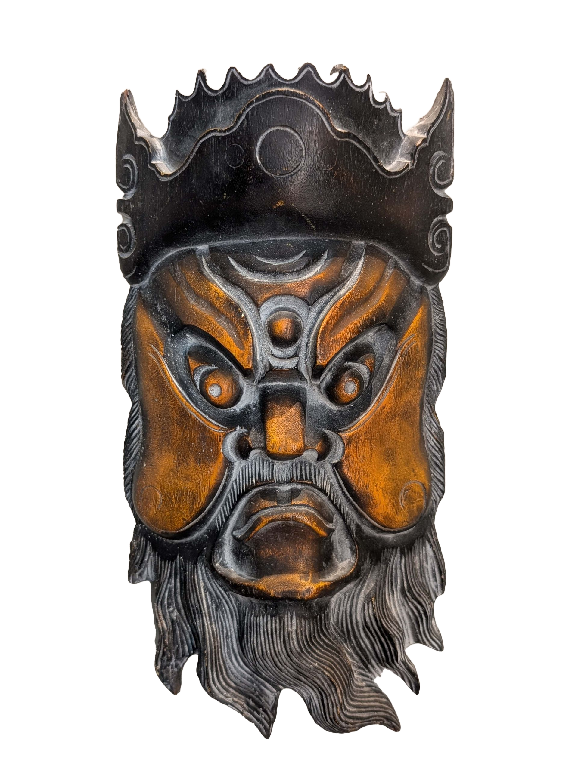 Carved wooden mask of a stern, bearded face, with a crown-like headpiece.