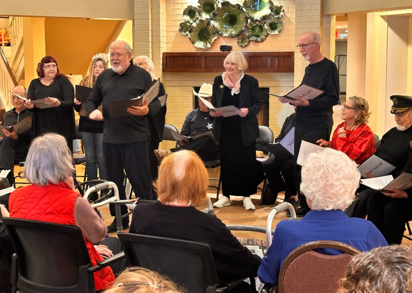Choir singing for a seated audience in a warmly lit room. Most hold sheet music.