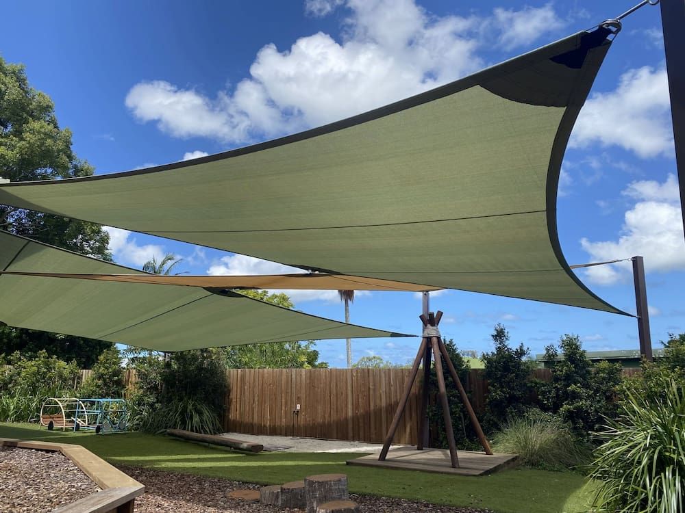 A Large Green Shade Sail Is Hanging Over A Playground — SPF Shades and Sails in Tweed Heads West, NSW