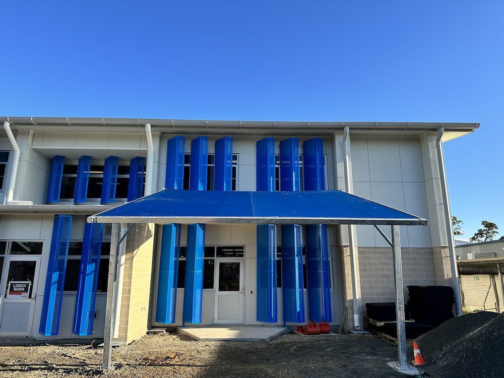 A Building With A Blue Awning On The Front Of It — SPF Shades and Sails in Tweed Heads West, NSW