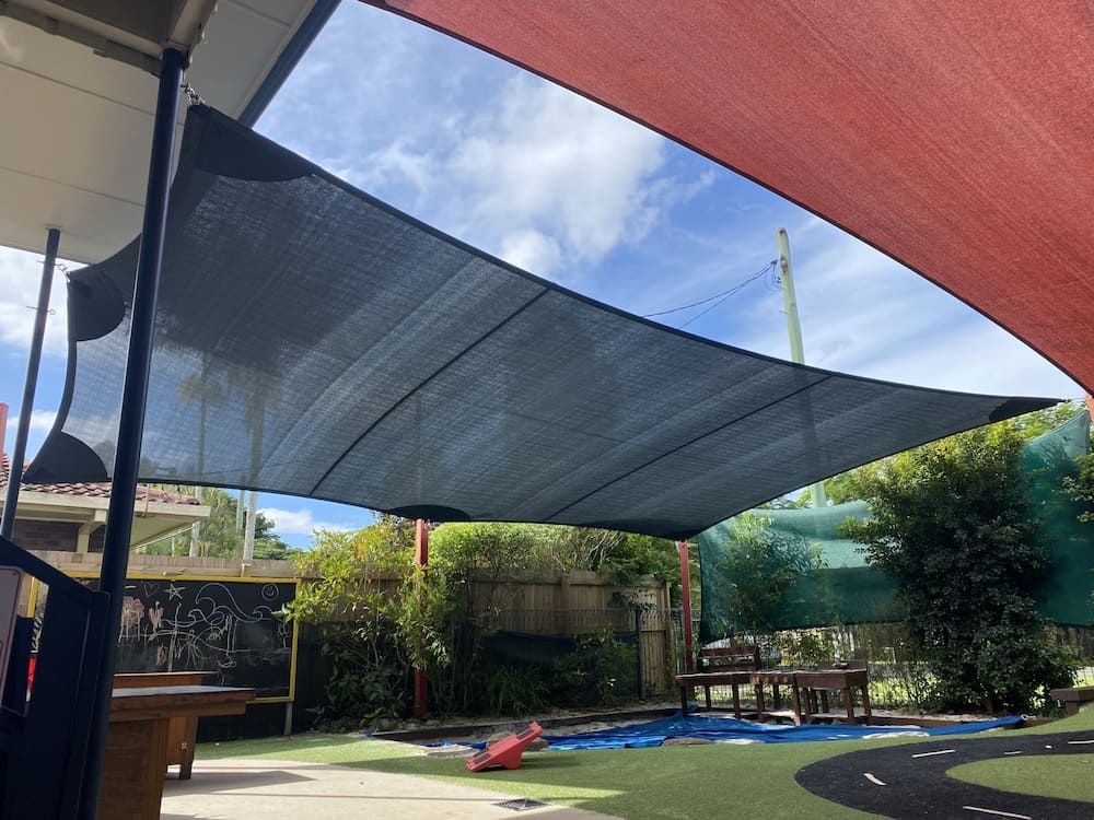 A Large Umbrella Is Covering A Pool In A Backyard — SPF Shades and Sails in Tweed Heads West, NSW