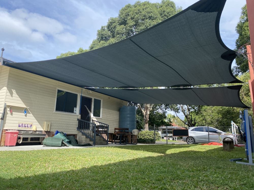 A Large Shade Sail Is Covering The Backyard Of A House — SPF Shades and Sails in Tweed Heads West, NSW