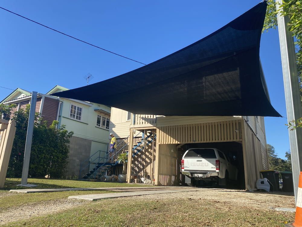 A Car Is Parked Under A Shade Sail In Front Of A House — SPF Shades and Sails in Tweed Heads West, NSW