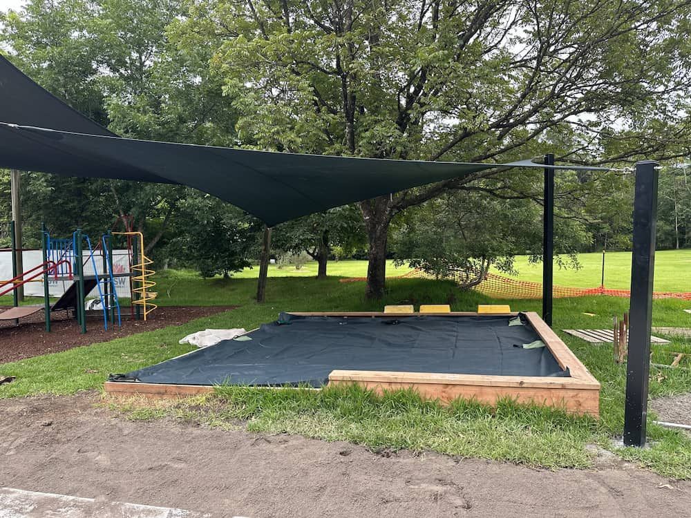 A Sandbox Is Sitting Under A Canopy In A Park — SPF Shades and Sails in Tweed Heads West, NSW