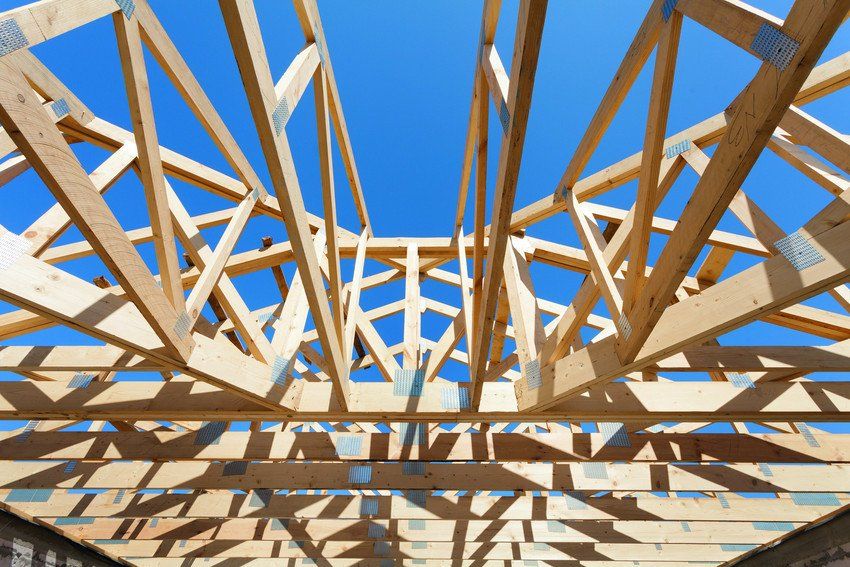 New residential wooden construction home framing against a blue sky