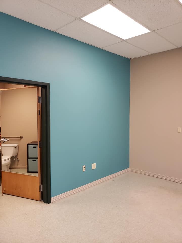 An empty room with blue walls and a toilet