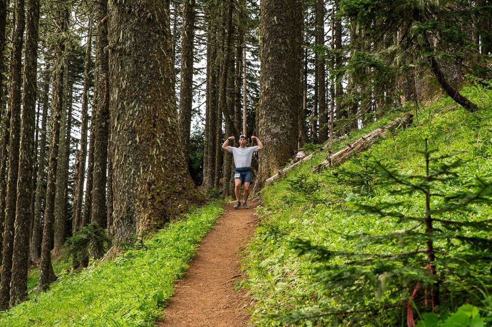 A man is running on a dirt road in the mountains.