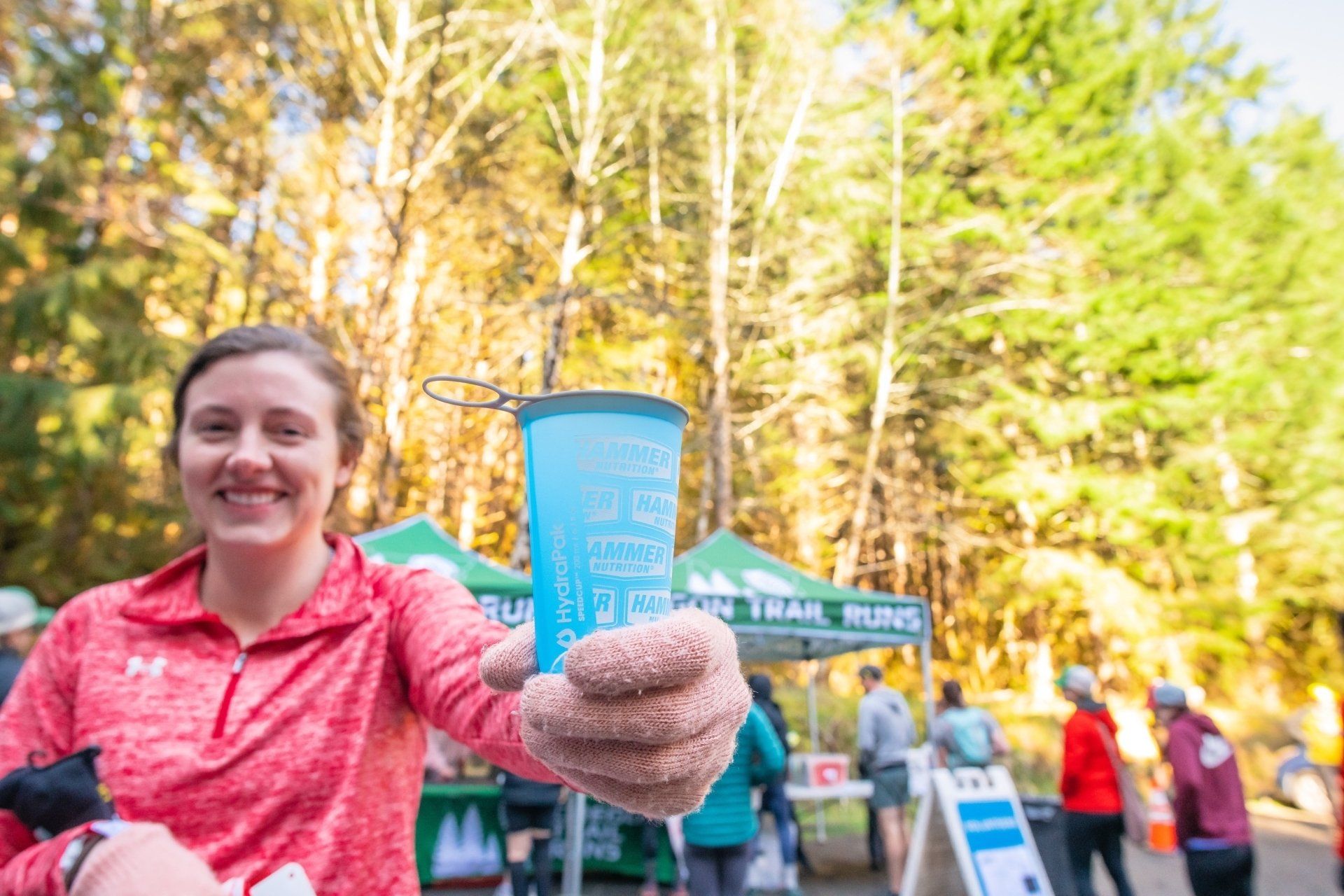 A woman is holding a cup of water in her hand.