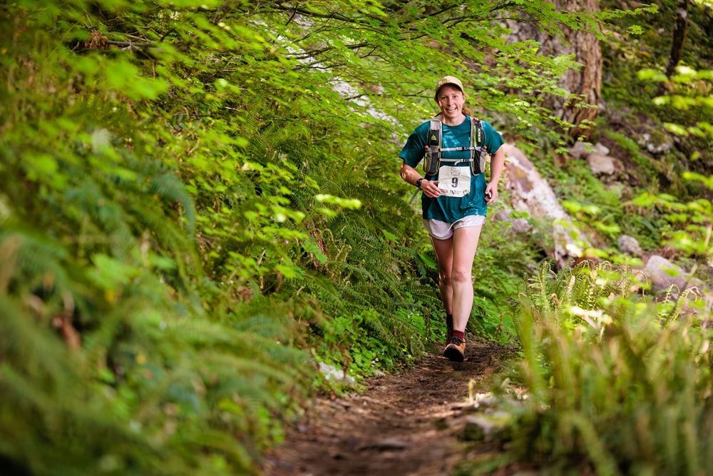 A man is running on a dirt road in the mountains.