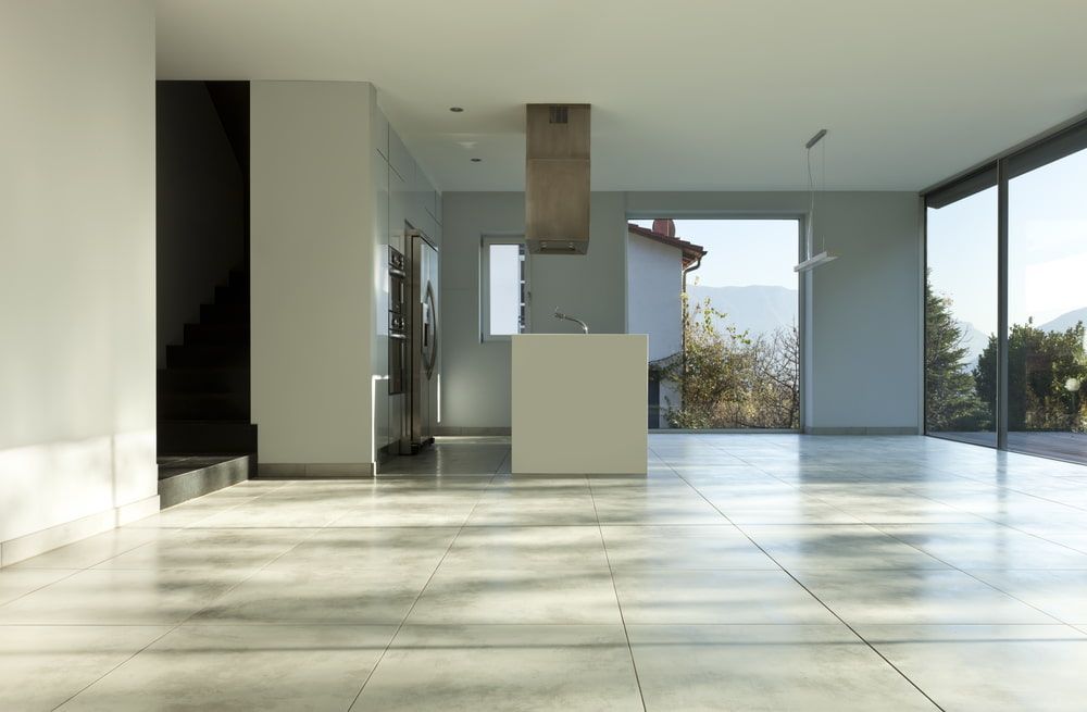 An Empty Room with A Kitchen Cabinets and A Large Window — Cooloola Tile Company in Sunshine Coast, QLD