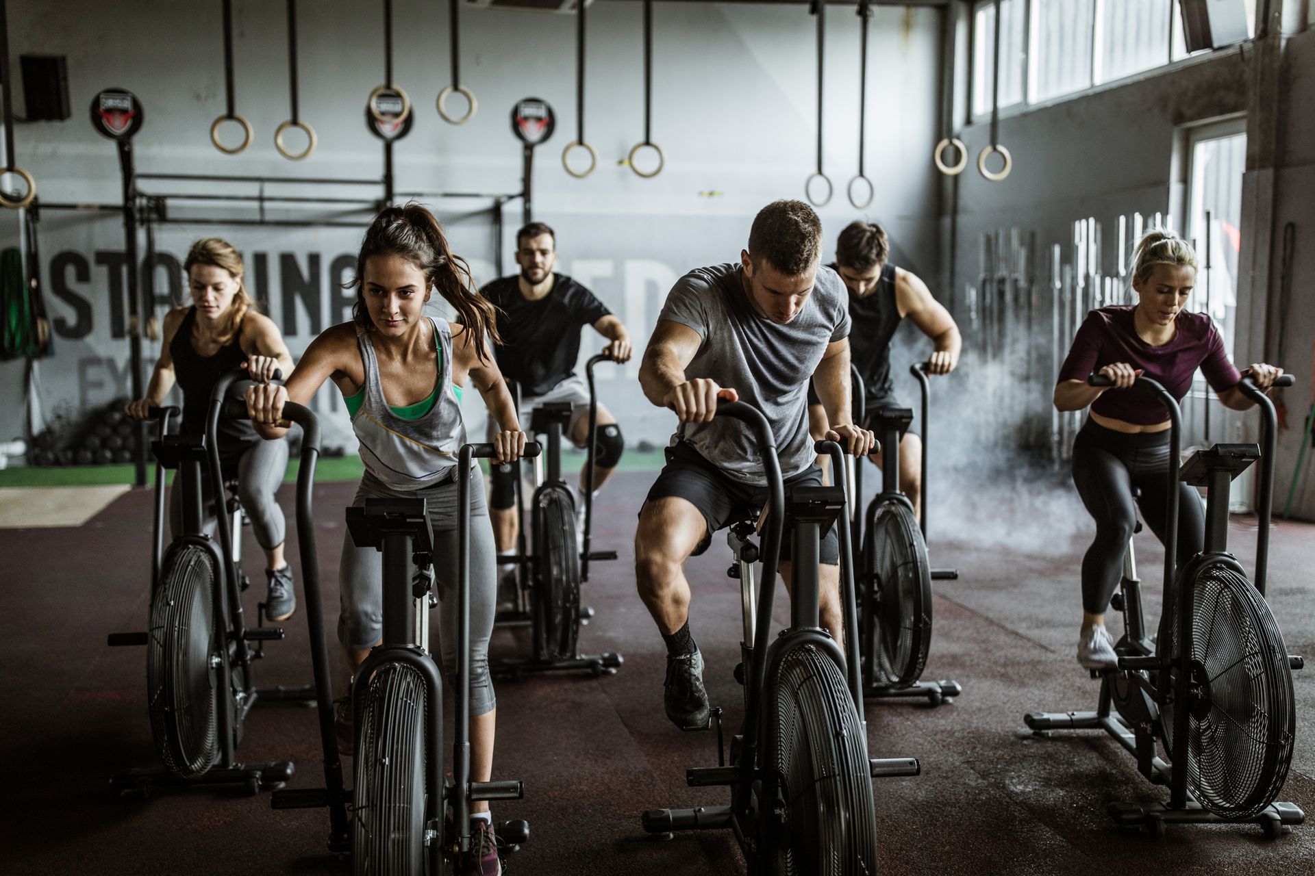 People exercising on stationary bikes in a gym.